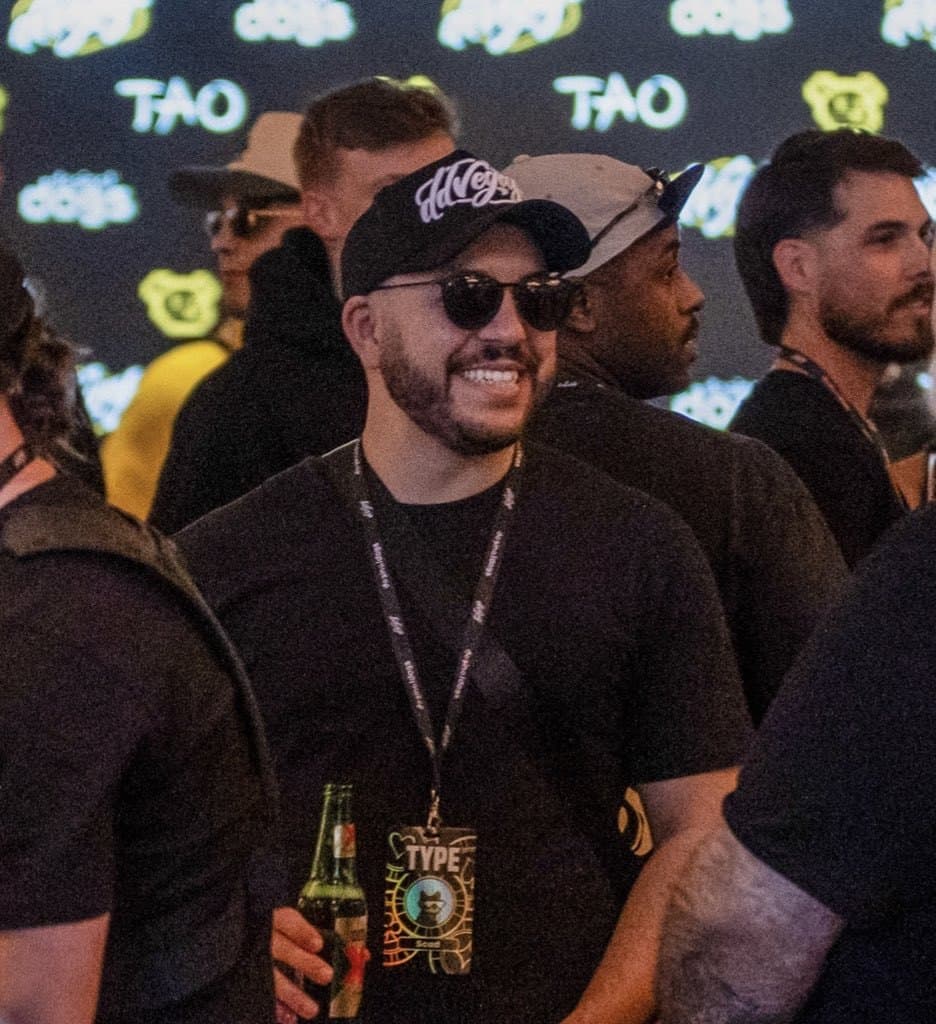 ScadMeta (@ScadMeta) in a black cap and sunglasses with a Type lanyard at a TAO event